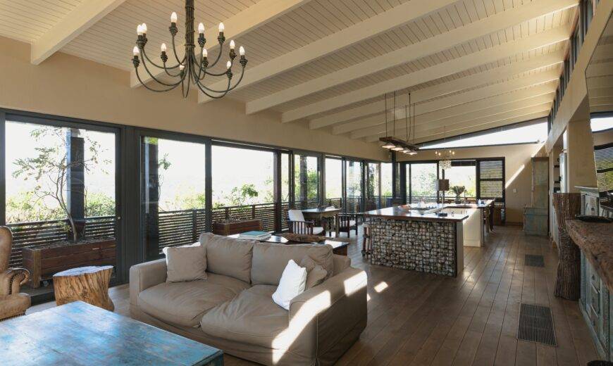 Large open concept room, kitchen behind the living room couch.