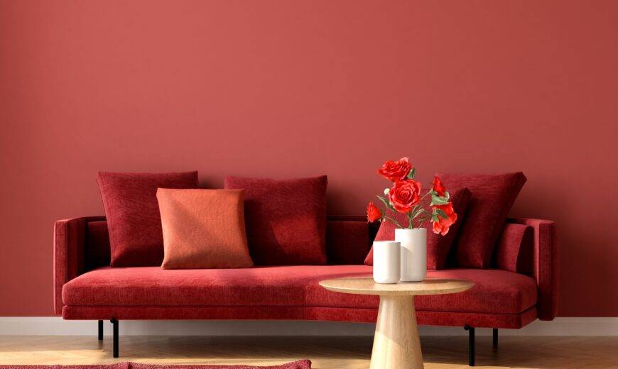 A monochromatic room with red walls, a red couch, and a red rug.