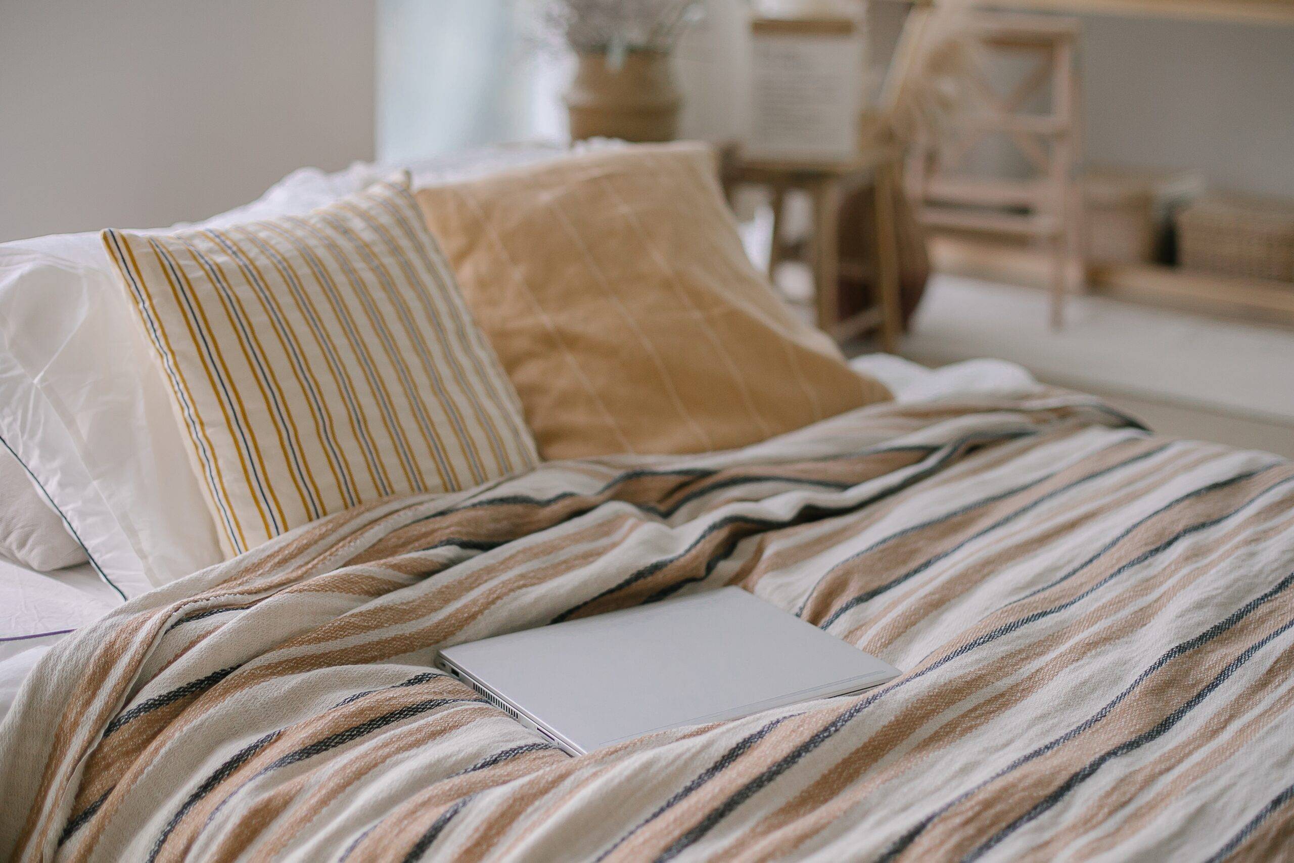 A close photo of a bed with beige bedding.