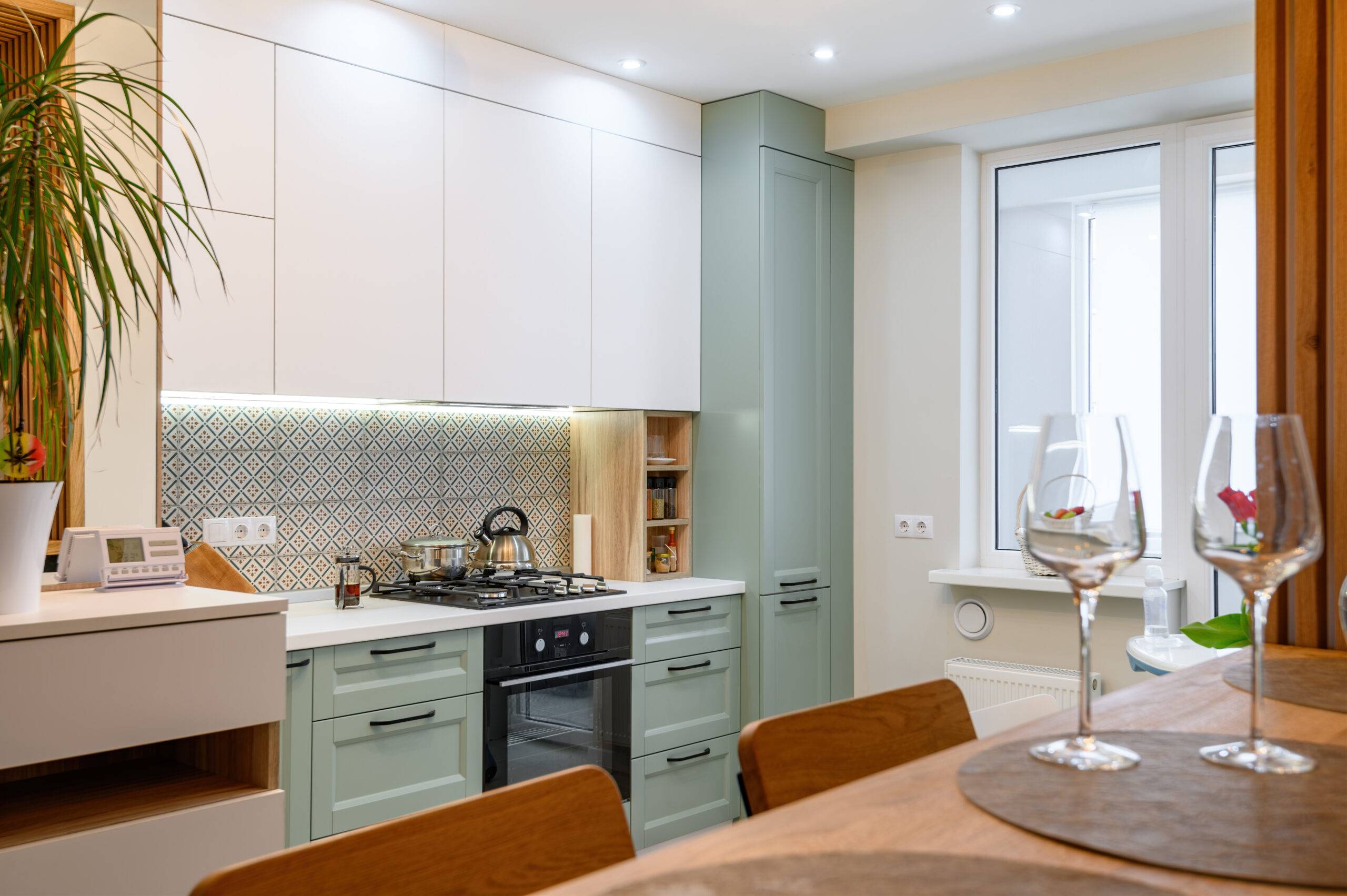 Modern brand new orange, white and teal kitchen interior with dining zone, clean design