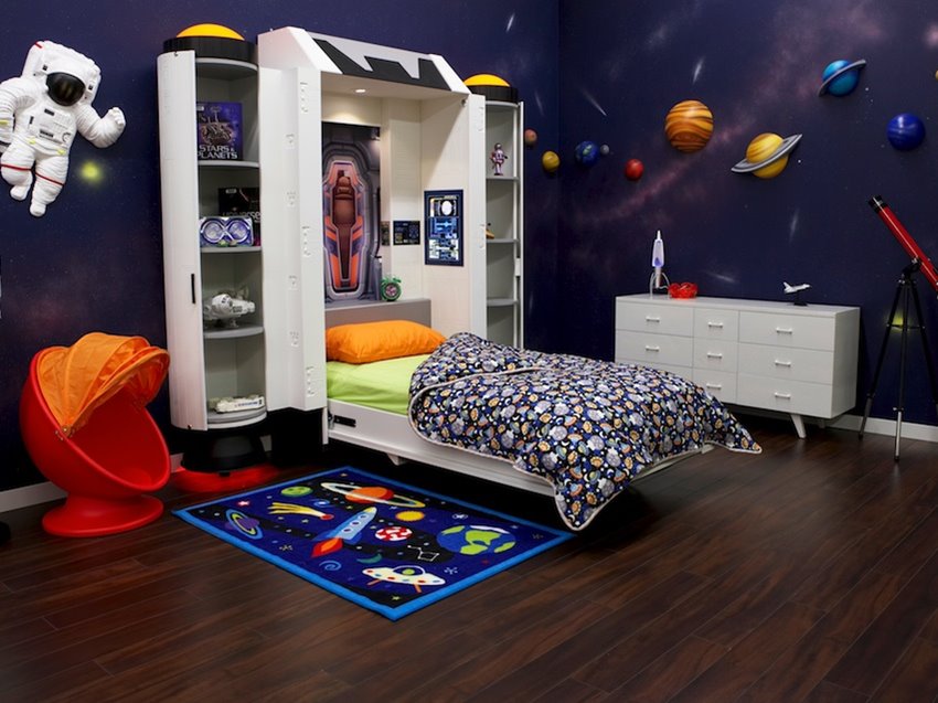 Space-themed child bedroom with planet artwork on the walls and a themed carpet.