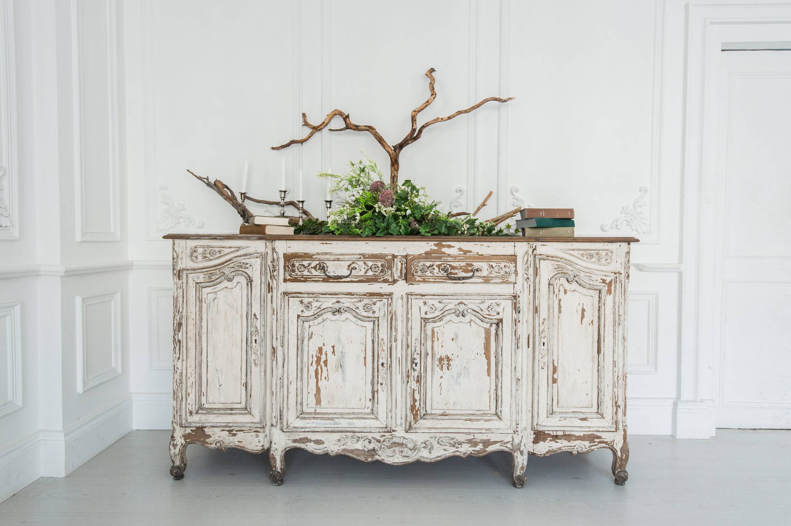 White commode with plants and handmade wool decoration.