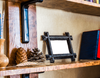 A bookshelf with a small picture frame on it next to a row of books.